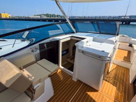 A spacious interior view of a modern boat's helm and seating area, showcasing the elegant design and functionality ideal for comfortable cruising.