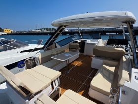 A spacious and well-designed interior of a boat featuring comfortable seating and a helm, perfect for relaxing and navigating on the water.