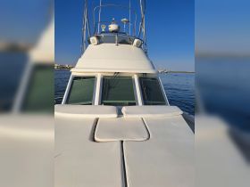 A close-up view of the front deck of a yacht, showcasing the sleek design and comfortable seating area, perfect for relaxing on the water.