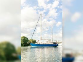A couple shares a romantic moment aboard a beautiful yacht, surrounded by scenic waters and lush greenery — perfect for intimate celebrations or special occasions.