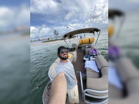 A joyful moment captured on a pontoon boat, with the captain taking a selfie while enjoying a beach day — perfect for group outings and fun on the water.