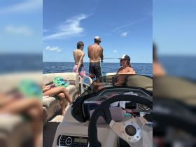 A family enjoys a sunny day fishing from their boat, capturing the essence of summer fun on the water.