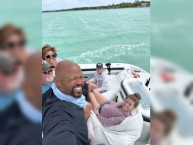A joyful group of friends enjoys a fun day on the water, capturing memories aboard their boat with smiles and laughter.