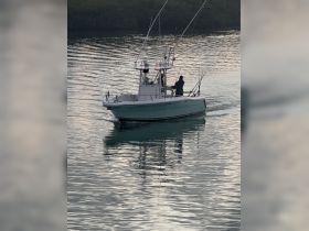A fishing boat navigates through calm waters, showcasing the thrill of fishing adventures on the water.