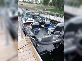 Interior view of a fishing boat showcasing the helm and seating area, ideal for anglers looking to enjoy a day on the water.