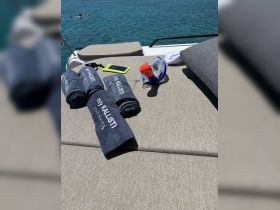A relaxing setup on a boat featuring towels, snorkel gear, and a phone, perfect for a day of sun and water activities.