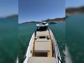 A spacious lounge area on a luxury boat, featuring comfortable seating and a sleek design, perfect for relaxing on the water.