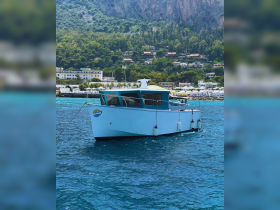 A beautiful boat anchored in clear turquoise waters, surrounded by lush greenery and coastal scenery, perfect for exploring the coastline.