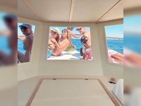 A lively group of friends enjoys their time aboard a boat, capturing the fun and camaraderie through the windows — perfect for memorable outings on the water.