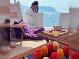 A vibrant display of snacks and colorful treats on a boat, with a guest enjoying the view — perfect for a relaxing day on the water.