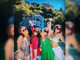 A joyful group of friends celebrates on a boat, raising their glasses against a picturesque backdrop — perfect for unforgettable moments on the water.
