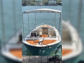 A clear view of a well-maintained boat docked by the water, showcasing its inviting deck and seating area, perfect for leisurely outings.