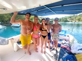 A cheerful group enjoys drinks on a boat, capturing the essence of a fun-filled day on the water — perfect for summer celebrations and family outings.
