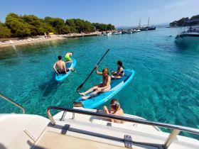 A fun day on the water as a group enjoys paddleboarding in crystal-clear waters, perfect for summer adventures and beach outings.