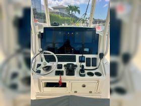 A detailed view of the helm and console area inside a boat, showcasing modern navigation equipment and controls, ideal for boating enthusiasts.