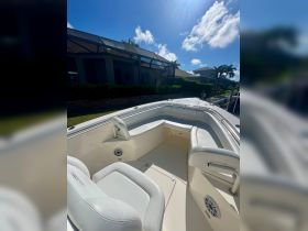 A spacious and well-appointed interior of a boat featuring comfortable seating and a sleek helm, perfect for relaxing on the water.