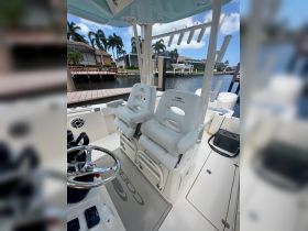 Inside view of a Cobia boat's helm area featuring comfortable seating and a sleek design, perfect for a day out on the water.