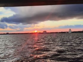 A stunning sunset over the water, capturing the vibrant colors reflecting on the waves — a perfect backdrop for evening boat cruises.