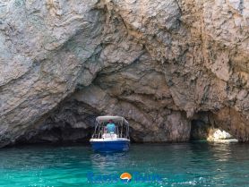 A boat navigates through a stunning cave, showcasing the beauty of the surrounding rock formations — an unforgettable tour experience.