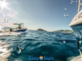 A thrilling view of a boat in motion on sparkling waters, showcasing the beauty of the coastline — perfect for adventure seekers exploring the sea.