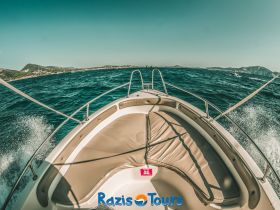 A stunning view from the front of a boat cruising through vibrant waters, showcasing the scenic coastline — perfect for adventure seekers and boat tours.