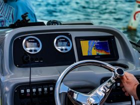 A close-up view of the helm and console of a boat, showcasing the Yamaha gauges and Garmin display, perfect for navigation and monitoring while on the water.