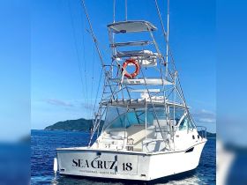 A striking view of the 'Sea Cruz' boat cruising through calm waters, showcasing its sleek design and fishing capabilities, perfect for ocean adventures in Costa Rica.
