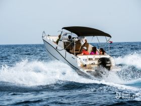 A lively group enjoys a thrilling ride on a speedboat, cutting through the waves of the ocean — perfect for adventure seekers and water enthusiasts.