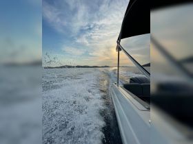 A stunning view of a boat in motion, capturing the spray of water and a beautiful sunset backdrop — perfect for showcasing the thrill of boating adventures.