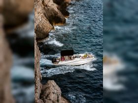 A group enjoys a thrilling ride on a boat along a rugged coastline, showcasing the excitement of on-water adventures.