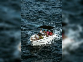 A lively group enjoys a boat ride, showcasing camaraderie and adventure on the water — perfect for team outings or family fun.