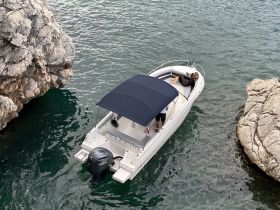 A couple enjoys a relaxing moment on a boat surrounded by stunning rocky scenery, perfect for a day of leisure on the water.