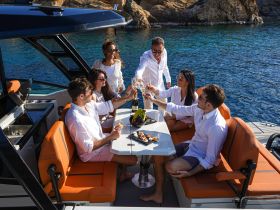 A lively group enjoys a toast with cocktails and gourmet food aboard a luxurious yacht, perfect for celebrating special moments on the water.