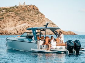 A lively group enjoys a day on a stylish yacht, celebrating with cocktails against a stunning coastal backdrop — perfect for memorable outings on the water.