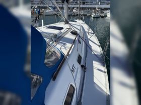 A close-up view of a sleek sailboat docked at the marina, showcasing its elegant design and rigging details.