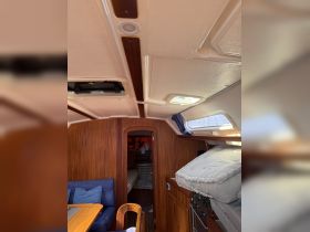 Interior view of a cozy boat cabin featuring comfortable seating and a well-equipped helm area, perfect for relaxing during your nautical adventures.