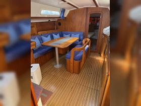 Interior view of a cozy boat cabin featuring comfortable seating and a dining area, perfect for relaxing and enjoying meals while at sea.