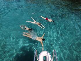 A group of friends enjoys a refreshing swim in crystal-clear waters, showcasing the perfect setting for snorkeling adventures.