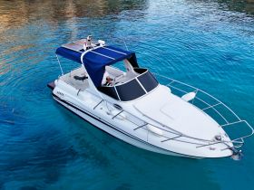 An aerial view of a sleek speedboat cruising through crystal-clear waters, showcasing its elegant design and inviting atmosphere for a perfect day on the water.