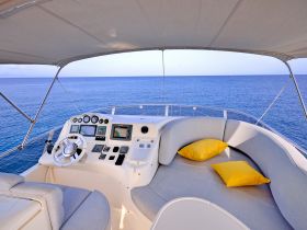 A well-appointed helm area of a yacht featuring modern navigation equipment and comfortable seating, perfect for enjoying a day on the water.