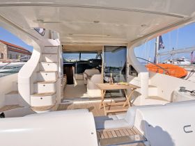 A beautifully designed interior of a yacht featuring a cozy lounge area with a table set for drinks and snacks, perfect for relaxing on the water.