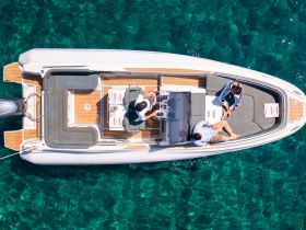 A group enjoys a relaxing moment aboard a stylish boat, complete with drinks and a beautiful turquoise backdrop — perfect for a day on the water.