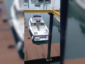 A sleek boat named 'Pique y Pique' docked at a marina, showcasing its modern design and spacious deck — perfect for fishing or leisure outings.