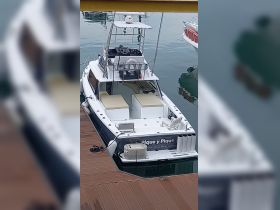 A sleek center console boat named 'Pique y Pique' docked at the marina, showcasing its spacious design and readiness for fishing or leisure outings.