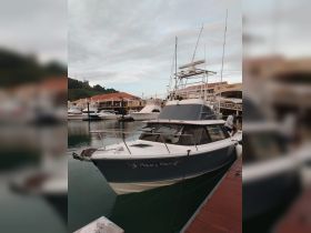 A sleek fishing boat named 'Pique y Pique' docked at a marina, showcasing its modern design and readiness for adventure on the water.