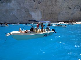 A lively scene at a stunning beach with a group enjoying the turquoise waters aboard a boat, perfect for summer adventures and family outings.