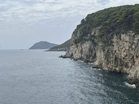 A stunning view of a rugged coastline and distant islands, showcasing the natural beauty of the area — perfect for scenic boat tours and exploration.
