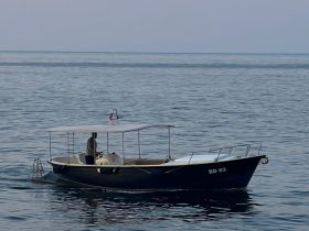 A sleek speedboat navigates calm waters, showcasing its design and functionality — perfect for leisurely outings or fishing trips.