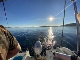 A serene view from a boat as the sun sets over calm waters, capturing the beauty of a peaceful boating experience.