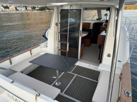 Interior view of a cozy dining area on a boat, featuring comfortable seating and a stylish table, perfect for enjoying meals while cruising.